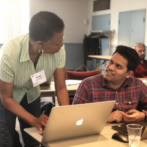 woman helping man with computer