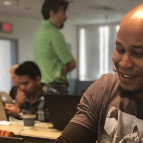 A man smiling while at a workshop.